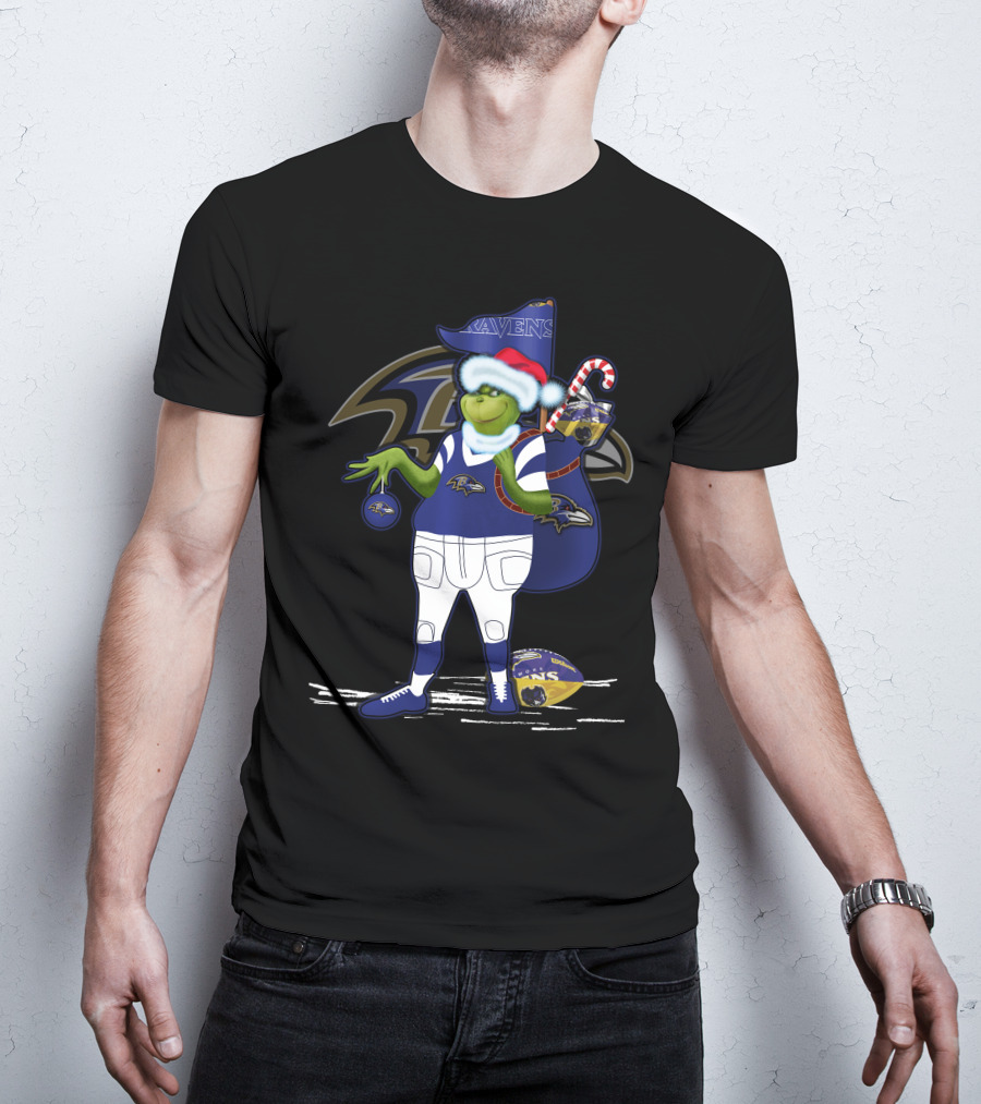 Grinch Santa Holding Candy Cane Bag And Baltimore Ravens Football In Ravens T-Shirt