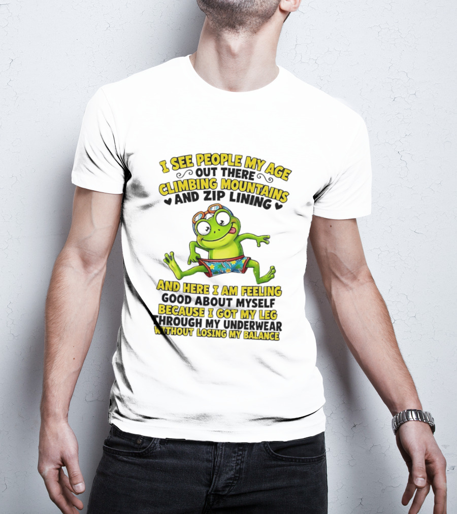 I See People My Age Climbing Mountains And Zip Lining Cartoon Frog Feeling Good Without Losing Balance T-Shirt